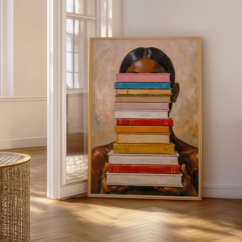 Puede incluir: Una impresi&oacute;n art&iacute;stica enmarcada que representa a una persona sosteniendo una pila de libros coloridos frente a su rostro. Los libros tienen varios colores, incluyendo azul, rosa, naranja y rojo. La obra de arte tiene un fondo c&aacute;lido y neutro.