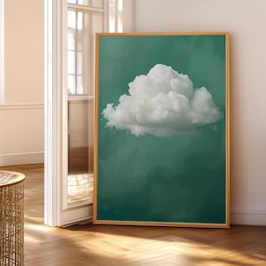 Puede incluir: Una impresión artística enmarcada que presenta una gran nube blanca y esponjosa sobre un fondo verde azulado. La nube está centrada, con una apariencia suave y texturizada. El marco es de color madera clara.