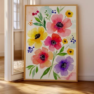 May include: A framed watercolour print of colourful flowers. The artwork showcases blooms in pink, yellow, orange, and purple, with green foliage and blue accents. The painting is set against a white backdrop and framed in wood.