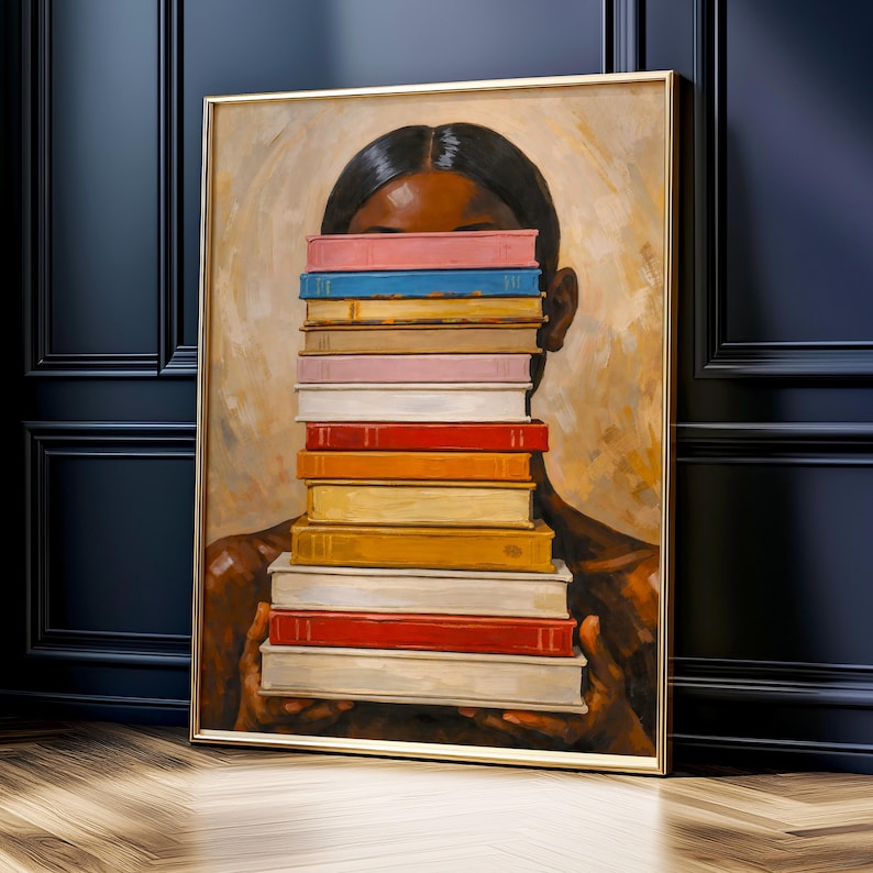 Puede incluir: Una pintura enmarcada representa a una persona sosteniendo una pila de libros coloridos frente a su rostro. Los libros tienen lomos de varios colores, incluyendo rosa, azul, naranja y rojo. La obra de arte tiene un fondo c&aacute;lido y neutro y un marco dorado.