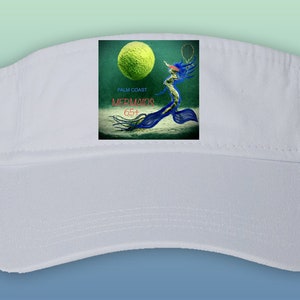 May include: White visor with a green, blue, and white graphic of a mermaid playing tennis. The graphic includes the text "Palm Coast Mermaids 65+"