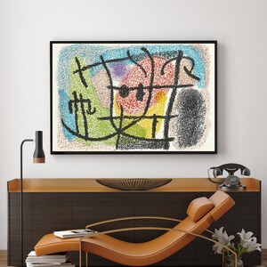 May include: Abstract painting with black lines and shapes on a white background. The painting features a variety of colors including red, yellow, green, blue, and purple. The painting is framed in a black frame and is hanging on a white wall above a brown wooden cabinet.