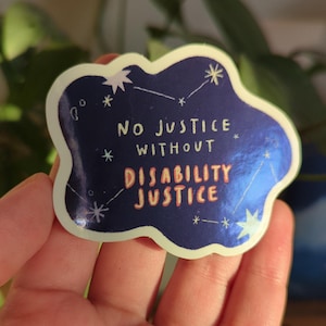 May include: A sticker with a dark blue background and a light blue border. The sticker has the text "NO JUSTICE WITHOUT DISABILITY JUSTICE" in white and red. The sticker also has white star and constellation designs.