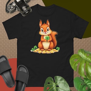 May include: A black t-shirt with a cartoon image of a squirrel holding a four-leaf clover and surrounded by gold coins.