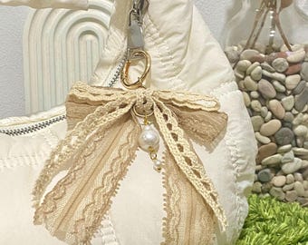 Llavero con lazo de encaje hecho a mano: elegante accesorio de cinta para bolso con cuentas de perla.