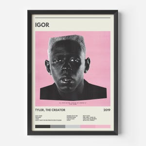 May include: A framed poster for Tyler, the Creator's "IGOR" album. The poster displays a black and white portrait of the artist on a pink backdrop. The album title and artist's name are at the top and bottom, with song titles listed below.
