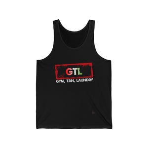 May include: Black vest top featuring the text "GTL" in a red and green rectangle, with the words "GYM, TAN, LAUNDRY" underneath. The top is sleeveless and made of a soft material.