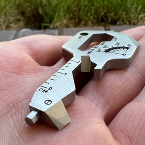 May include: A silver multi-tool key with a ruler, wrench, and screwdriver. The tool also has a small gauge with markings for 90, 50, and 30 degrees.