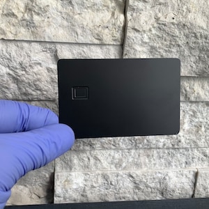 Leerer Metall-Debit-Kreditkartenchip mit Magnetstreifen in Gold oder Edelstahl auf Schwarz