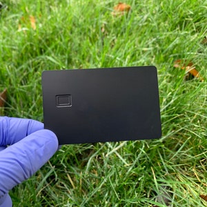 Leerer Metall-Debit-Kreditkartenchip mit Magnetstreifen in Gold oder Edelstahl auf Schwarz