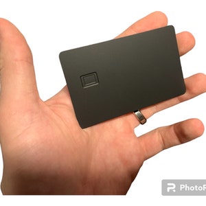 Leerer Metall-Debit-Kreditkartenchip mit Magnetstreifen in Gold oder Edelstahl auf Schwarz