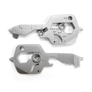 Peut inclure: Deux outils multifonctions argentés avec différentes tailles de clés hexagonales, une règle et un rapporteur. Les outils sont étiquetés avec les tailles M2, M2.5, M3, M3.5, M4, M5 et 3/8 de pouce.