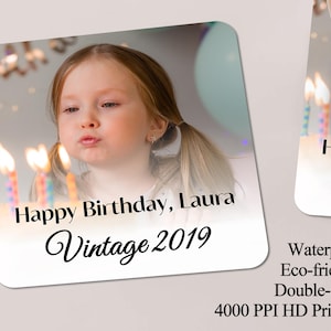 May include: Square coaster with a photo of a young girl blowing out birthday candles. The coaster has the text "Happy Birthday, Laura Vintage 2019". The coaster is double-sided and waterproof.