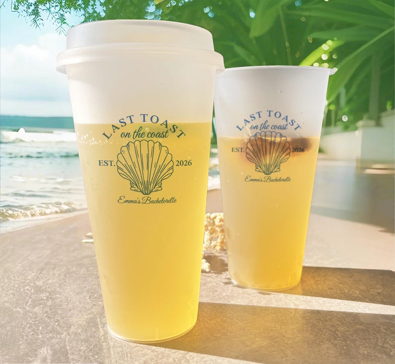 K&ouml;nnte beinhalten: Zwei durchsichtige Plastikbecher mit gelber Fl&uuml;ssigkeit. Die Becher haben ein schwarz-wei&szlig;es Design mit dem Text "Last Toast on the Coast" und einer Muschelgrafik. Der Text "Est. 2026" und "Emma's Bachelorette" sind ebenfalls auf den Bechern enthalten.