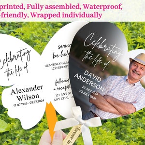 May include: Memorial fan with a butterfly and heart shape. The butterfly fan reads "Celebrating the life of Alexander Wilson" with dates. The heart-shaped fan features a photo and reads "Celebrating the life of David Anderson" with dates.