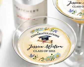 May include: A set of two champagne flute glass stickers with a floral design and a graduation cap. The stickers say "Congratulations Jessica Wilson Class of 2025".