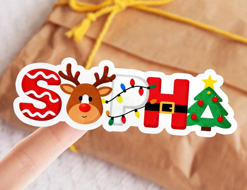 May include: A colorful sticker with the name "SOPHIA" in a Christmas theme. The letter "S" is red with a white wavy pattern, followed by a reindeer. The letter "P" has Christmas lights, "H" has a Santa belt, and a Christmas tree.