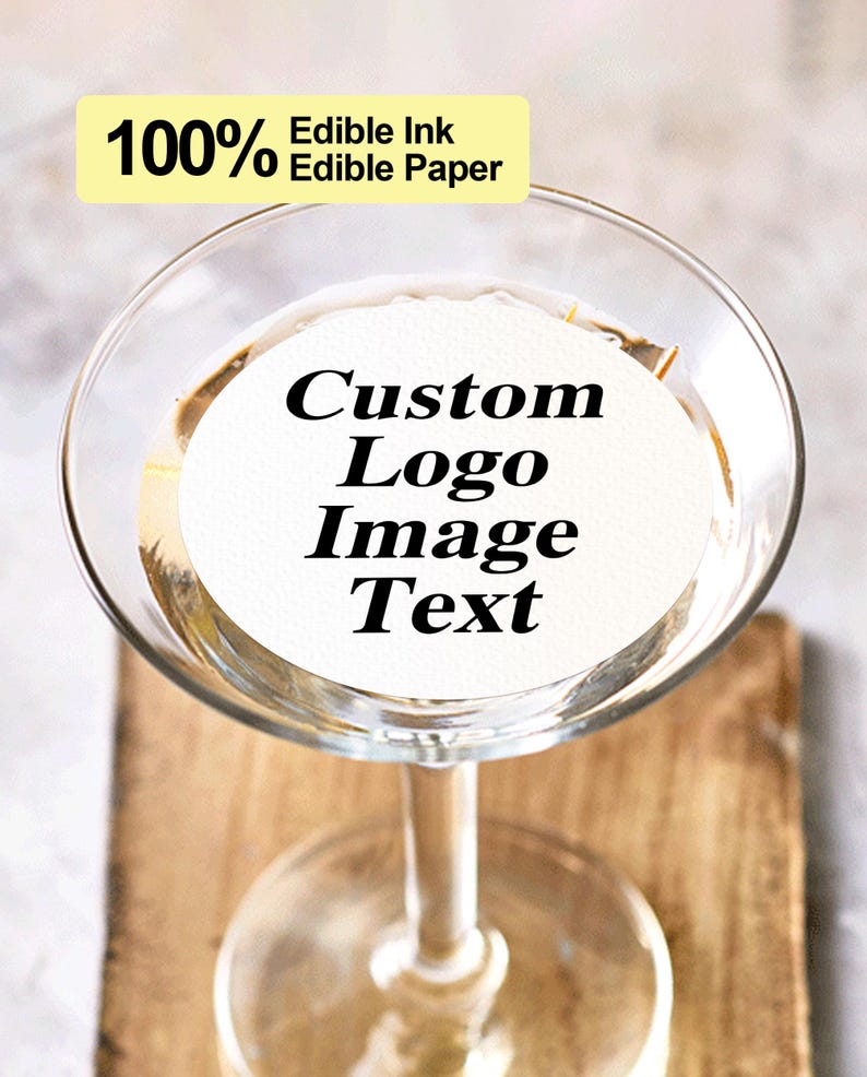 K&ouml;nnte beinhalten: Ein klares Martini-Glas aus Glas mit einer wei&szlig;en essbaren Papierscheibe im Inneren. Die Scheibe tr&auml;gt den Text "Custom Logo Image Text". Der Text "100% Edible Ink Edible Paper" ist auf einem gelben Rechteck in der oberen linken Ecke des Bildes gedruckt.