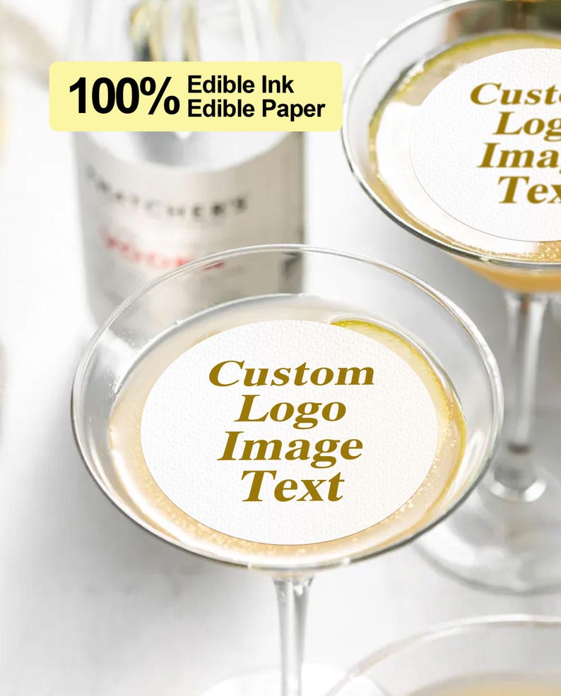 K&ouml;nnte beinhalten: Zwei Martinigl&auml;ser mit essbaren Papierkreisen, auf denen "Custom Logo Image Text" und "Custom Logo Image Text" steht. Das essbare Papier besteht aus 100% essbarer Tinte und essbarem Papier.