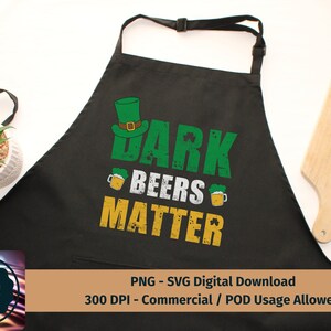 May include: Black apron with a green shamrock design and the text "Dark Beers Matter".