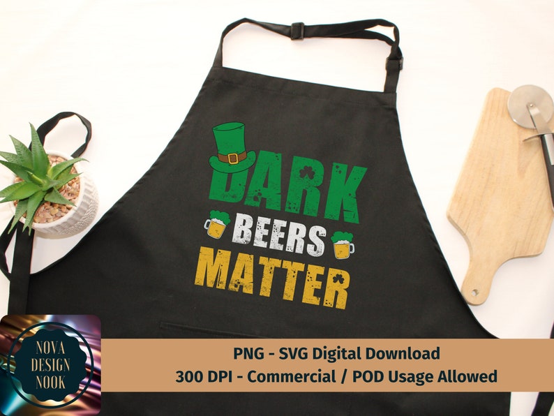 May include: Black apron with a green shamrock design and the text "Dark Beers Matter".