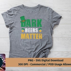 May include: A gray t-shirt with a distressed green, yellow, and white graphic that says "Dark Beers Matter". The graphic includes a cartoon leprechaun hat.