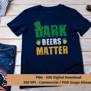 May include: A dark blue t-shirt with a green, white, and gold graphic design. The graphic features a leprechaun hat, beer mugs, shamrocks, and the text "Dark Beers Matter".