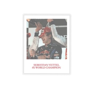 May include: A framed photograph featuring Formula 1 driver Sebastian Vettel celebrating a victory. He is wearing a red cap and a racing suit, holding a champagne bottle. The text "SEBASTIAN VETTEL 4X WORLD CHAMPION" is printed in red at the bottom.