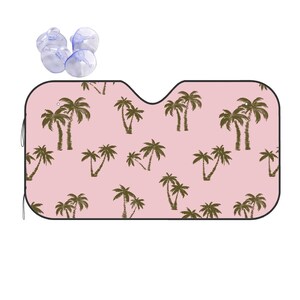 May include: Pink car sunshade with a repeating pattern of brown palm trees. The sunshade has suction cups to attach to the windscreen.