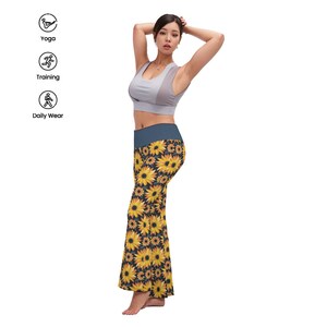 Puede incluir: Un pantalón de yoga negro con estampado de girasoles. El pantalón tiene pierna ancha y cintura alta.