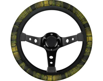 May include: A black steering wheel with a green and yellow camouflage pattern. The wheel has a black leather grip and a black metal center hub.