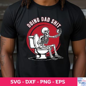 May include: A black t-shirt with a red circle and the text "Doing Dad Shit" in white. Inside the circle is a skeleton sitting on a toilet and taking a selfie.
