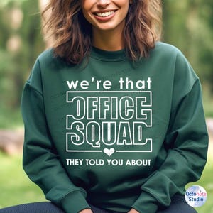 Cheerful girl in forest-green sweatshirt featuring That Front Office Squad, perfect for casual Fridays and teacher gift ideas. Screen it on sweatshirts, thermoses, or folders.
