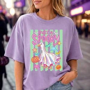 Halloween Goose with stripes displayed on a lavender oversized short sleeve t-shirt. Great for preppy halloween, spooky season, and trendy pastel shirt designs.