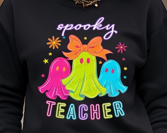May include: Black sweatshirt with a colorful Halloween design. The design features three cartoon ghosts in pink, green, and blue, with the word "spooky" above and "TEACHER" below. Orange bow, stars, and flowers complete the design.