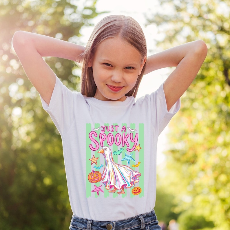 Halloween Goose with stripe background displayed on a kids white short sleeve t-shirt. Fun retro funny animal style for popular tshirt and Halloween outfit ideas.
