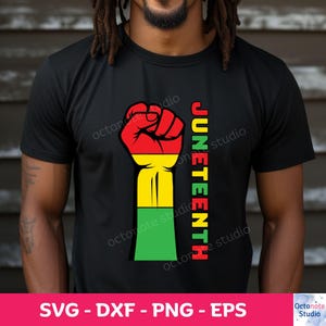 Peut inclure: Un t-shirt noir avec un graphique de poing levé en rouge, jaune et vert. Le texte "JUNETEENTH" est aligné verticalement à droite du graphique du poing.