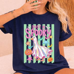 Halloween Goose with green stripe background on a navy short sleeve t-shirt.
A bold striped boutique spooky design with colorful retro Halloween charm.