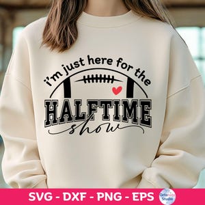 Può includere: Felpa color crema con la scritta nera "I'm just here for the HALFTIME show", una grafica di football e un cuore rosso. La parte inferiore dell'immagine mostra "SVG - DXF - PNG - EPS" e il logo Octonote Studio.