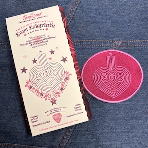 May include: A bandana and patch set with a heart-shaped labyrinth design. The bandana is 24" x 24" square, with text that reads "Love Labyrinth Bandana". The patch is a circular shape with a matching design. Both items are pink and white.