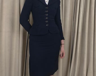 Traje de falda ajustado de lana azul marino estilo vintage con hombreras abullonadas.