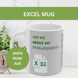 May include: White ceramic mug with a gray background and green text that reads "Ask me about my spreadsheets."  A green Excel icon is below the text.