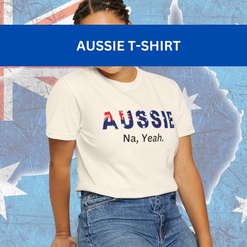 Puede incluir: Camiseta color crema con la palabra "AUSSIE" en rojo, blanco y azul, con la bandera australiana incorporada en las letras. Debajo, la frase "Na, Yeah". El fondo muestra la bandera australiana y un mapa.