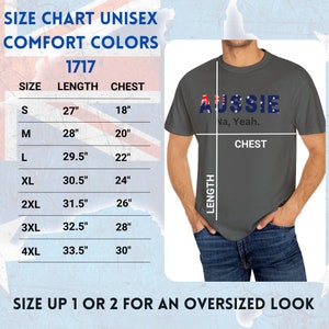 Puede incluir: Una camiseta unisex gris con la palabra "AUSSIE" en letras azules y la bandera australiana incorporada en el dise&ntilde;o. El texto "Na, Yeah" est&aacute; debajo. Se incluye una tabla de tallas, con medidas en cm para el pecho y la longitud.