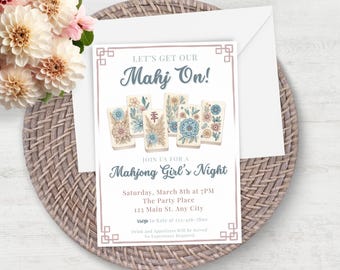Puede incluir: Una invitación a una noche de Mahjong para chicas. La invitación presenta un diseño floral rosa y azul con el texto "Let's Get Our Mahj On!" y "Join Us For A Mahjong Girl's Night". La invitación también incluye la fecha, la hora, la ubicación y la información de RSVP.