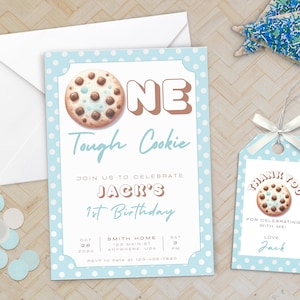 Könnte beinhalten: Eine blaue Einladungskarte mit weißen Punkten, einem Schokoladenkeks-Motiv und dem Text "One Tough Cookie" für eine erste Geburtstagsfeier. Die Einladung enthält auch den Namen "Jack's" sowie Datum und Uhrzeit der Feier.