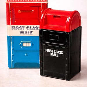 Pode incluir: Duas caixas de correio vintage, uma vermelha, branca e azul, e a outra preta e vermelha. Ambas têm o texto "FIRST CLASS MAIL". A caixa de correio vermelha, branca e azul é retangular, enquanto a preta e vermelha tem um topo curvo.