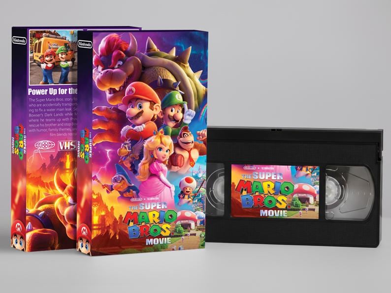 May include: The Super Mario Bros. Movie VHS tape and box set. The box art features Mario, Luigi, Princess Peach, and Bowser. The VHS tape has a colorful label with the movie title.