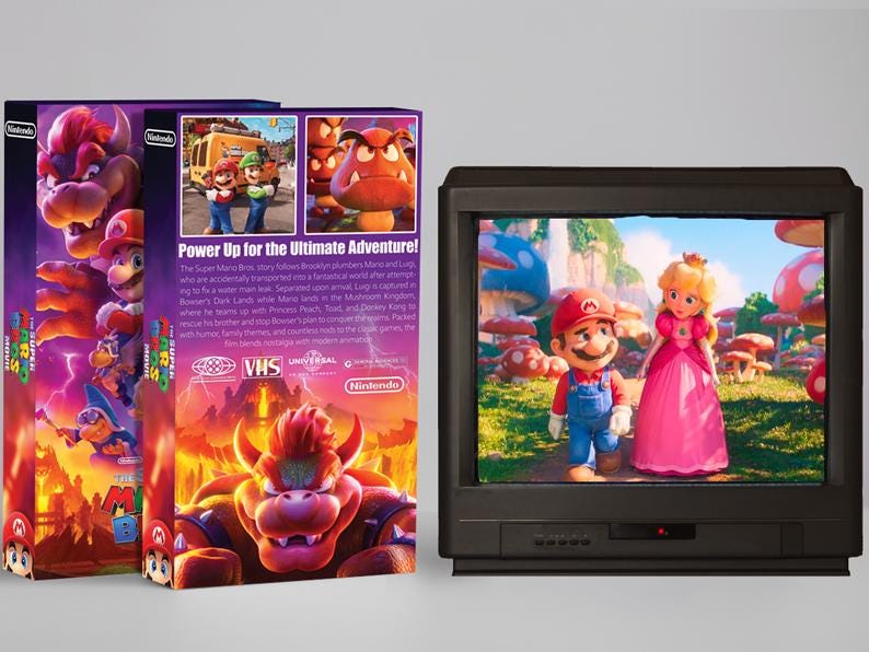 May include: A VHS tape box and a television displaying a scene from the Super Mario Bros. movie. The box is purple and features Bowser and other characters. The TV shows Mario and Princess Peach in a colorful mushroom kingdom.