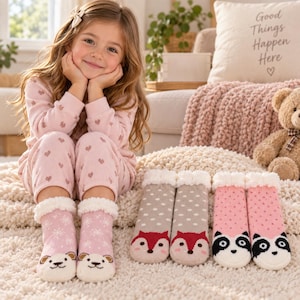 May include: Three pairs of plush slipper socks featuring animal faces. One pair is light pink with white snowflakes and bear faces, one is gray with white polka dots and fox faces, and one is pink with small triangles and panda faces.